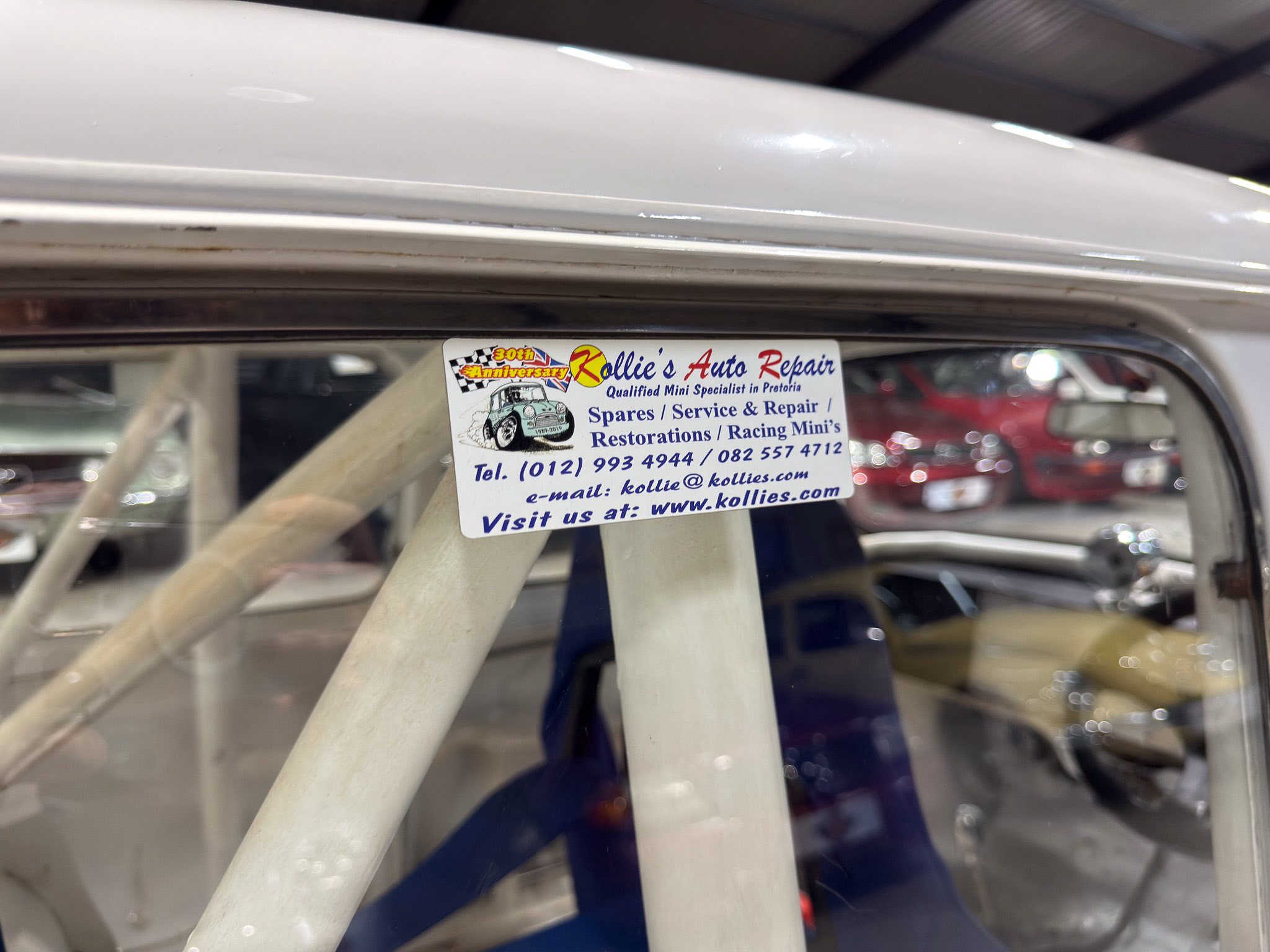 Sticker in a car window advertising Kollie's Auto Repair and services (Spares, Service & Repair) in Pretoria, with contact info visible.