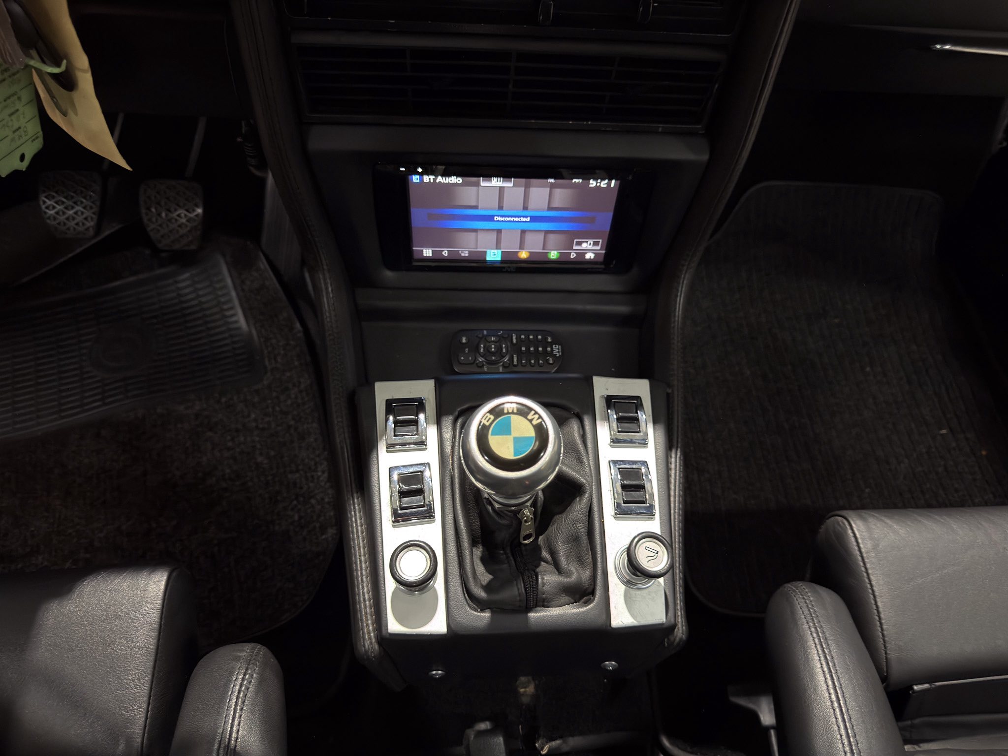 Center console of a car with a display screen showing 'Disconnected' and a BMW gear shifter nearby.