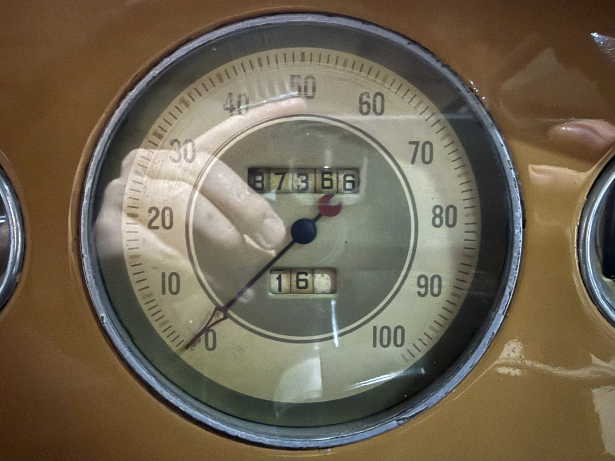 Close-up of a vintage car speedometer showing mph scale from 0 to 100 with the odometer reading 87366.