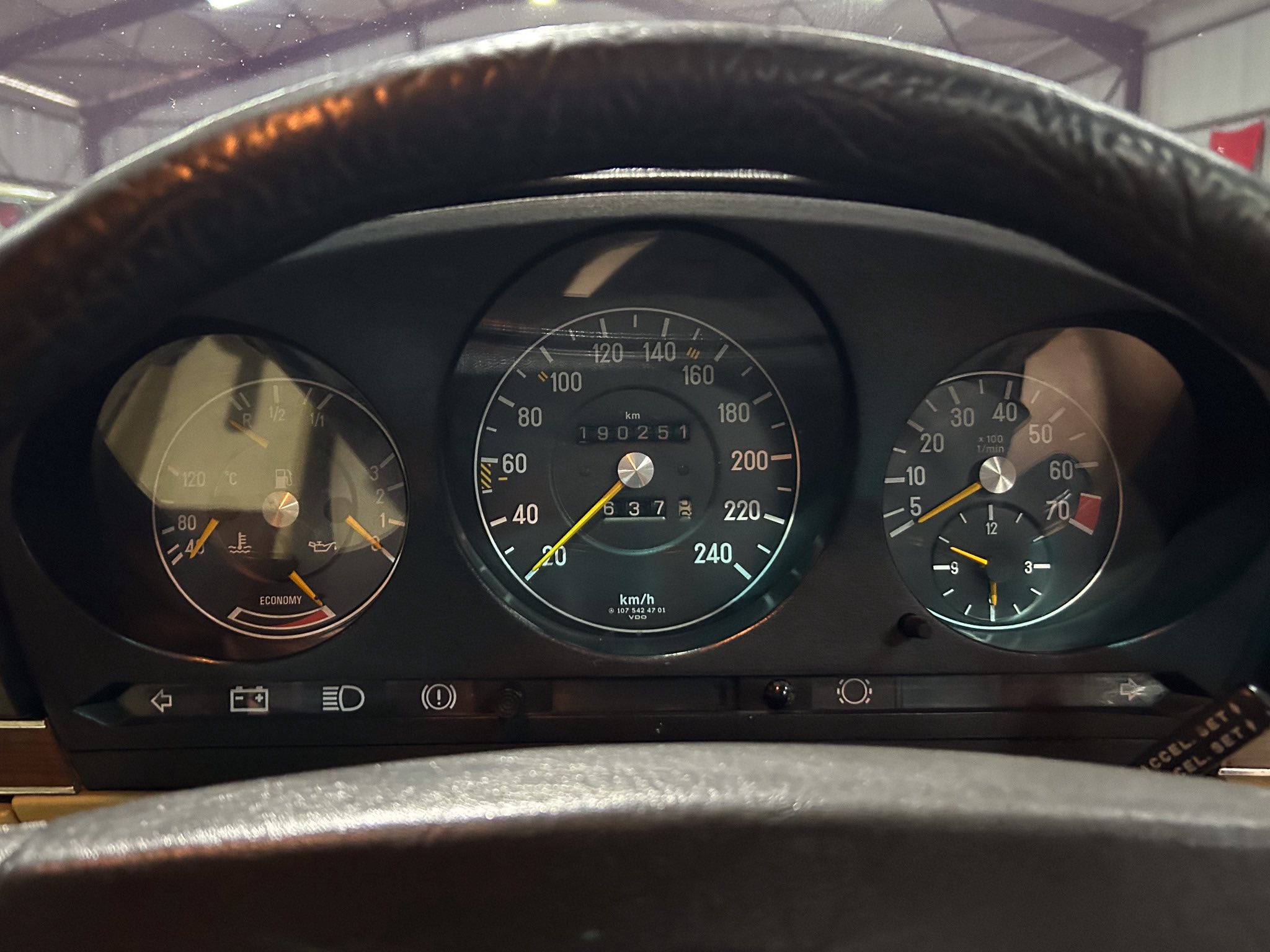 Close-up of a car instrument cluster from the driver's seat, showing speedometer and odometer reading 190,251 km.