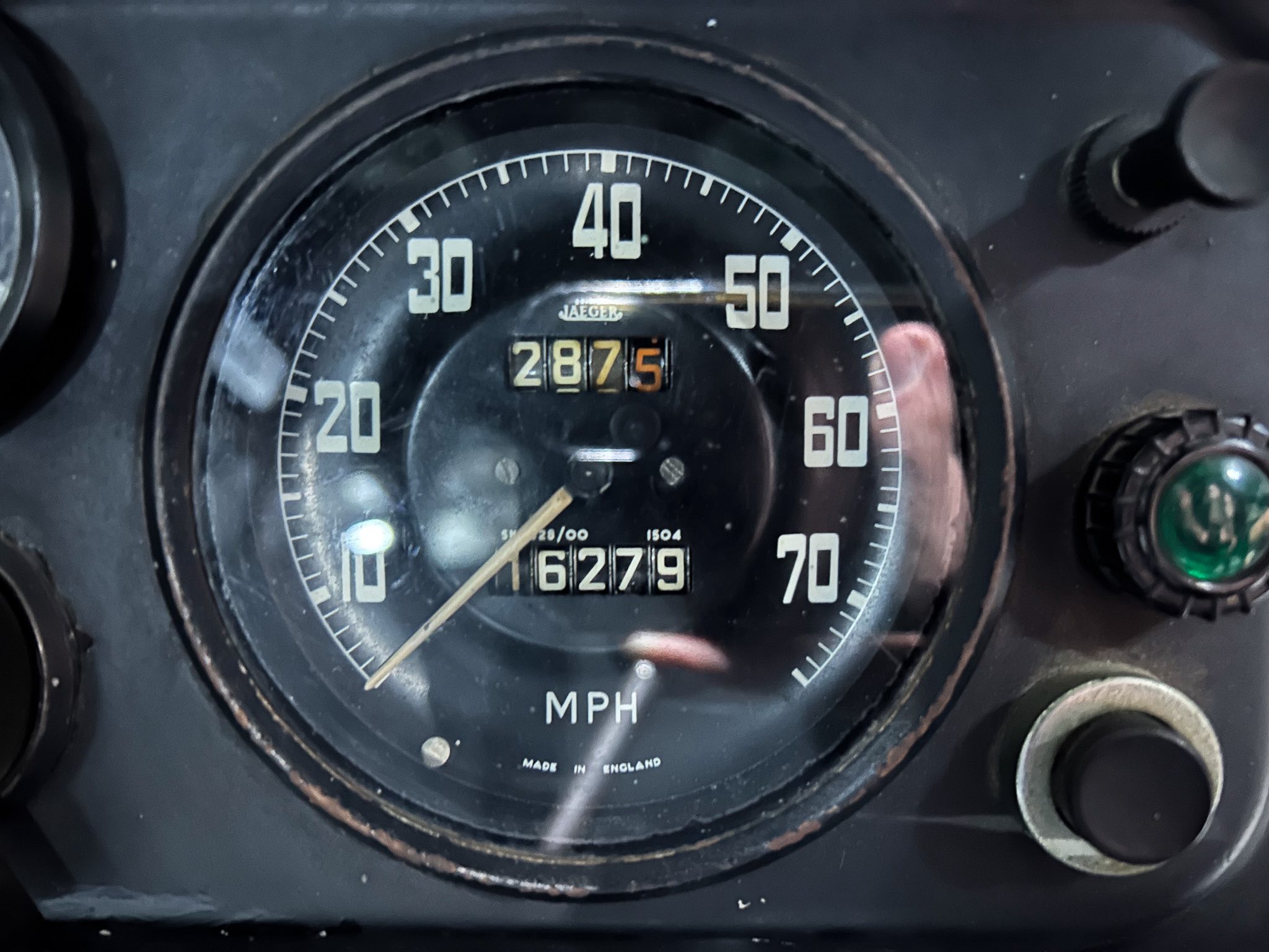 Close-up of a vehicle speedometer with the needle near 0 mph and odometer reading 2875 miles brought into view.