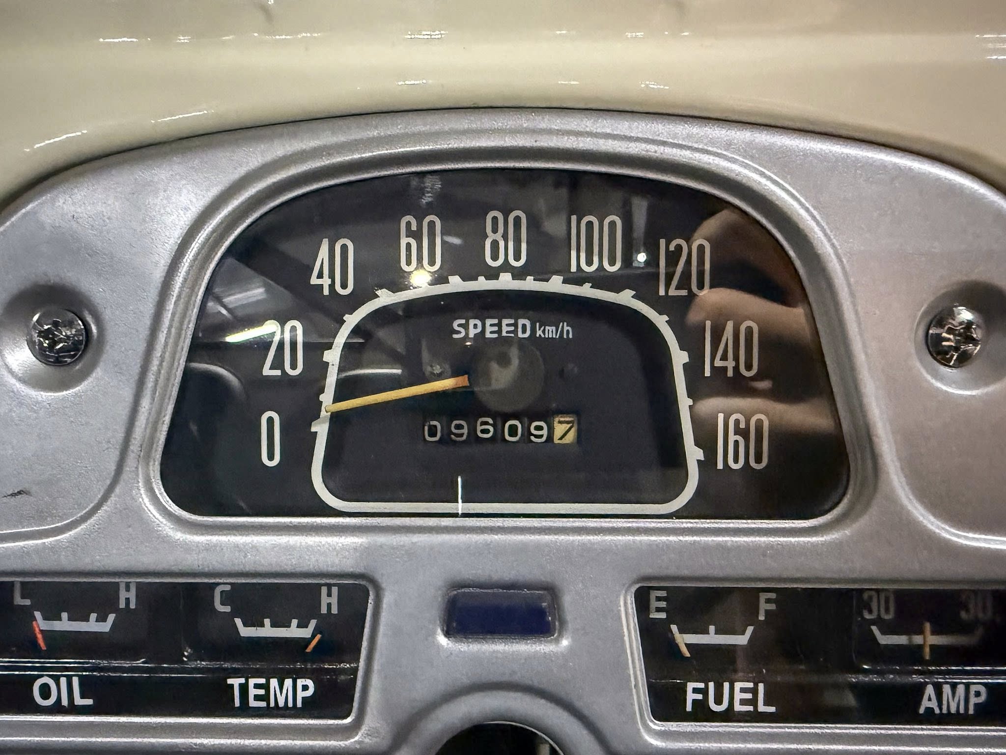 Close-up of an old car dashboard: analog speedometer marked SPEED km/h up to 160, with the odometer reading 096097 beneath, and labels for oil, temp, fuel visible below.