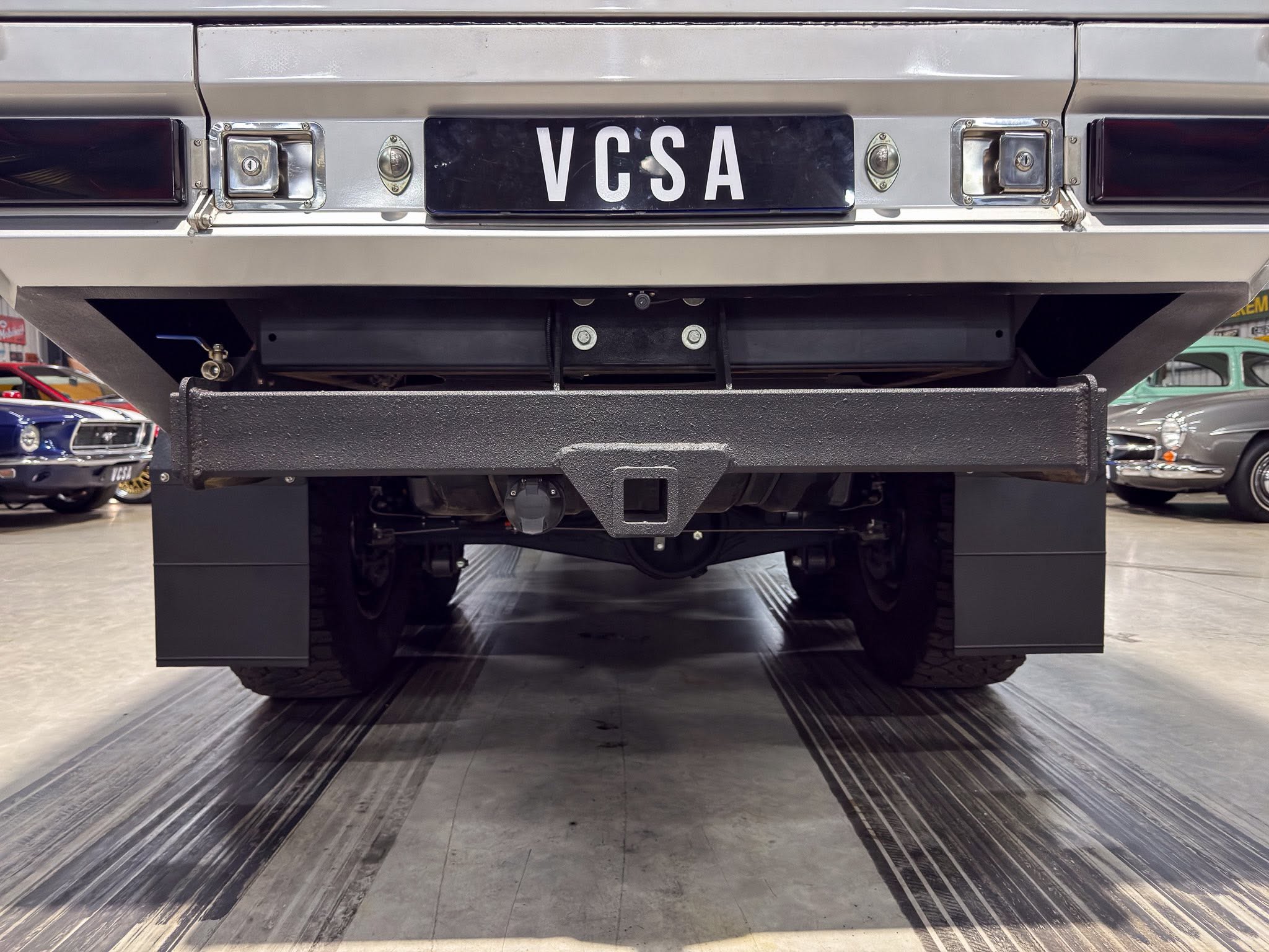 Rear view of a silver truck showing a black license plate reading VCSA.