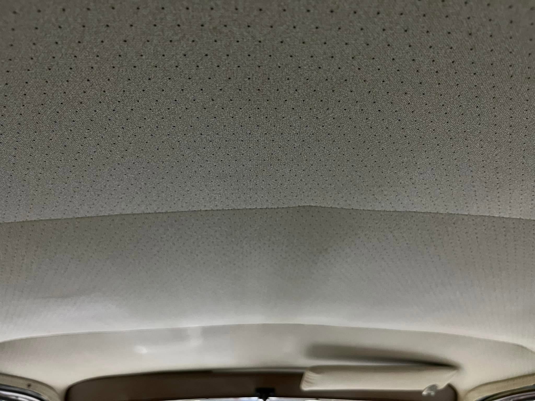 Gray perforated ceiling tiles with small circular holes (acoustic panels).