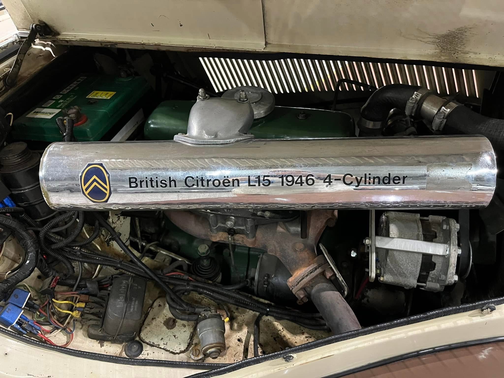 Engine bay of a 1946 British Citroën L15 4-cylinder, showing the silver hood latch and green engine block with battery on the left edge.