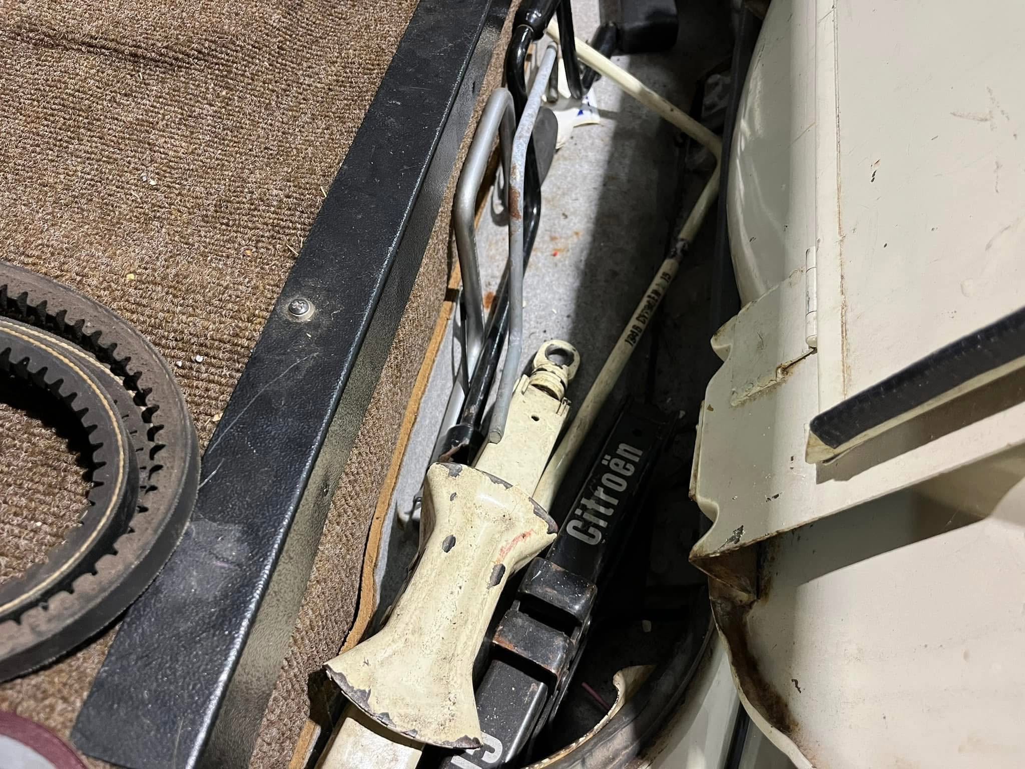 Close-up of a dusty mechanical interior with a toothed belt, wires, and metal supports inside a panel.