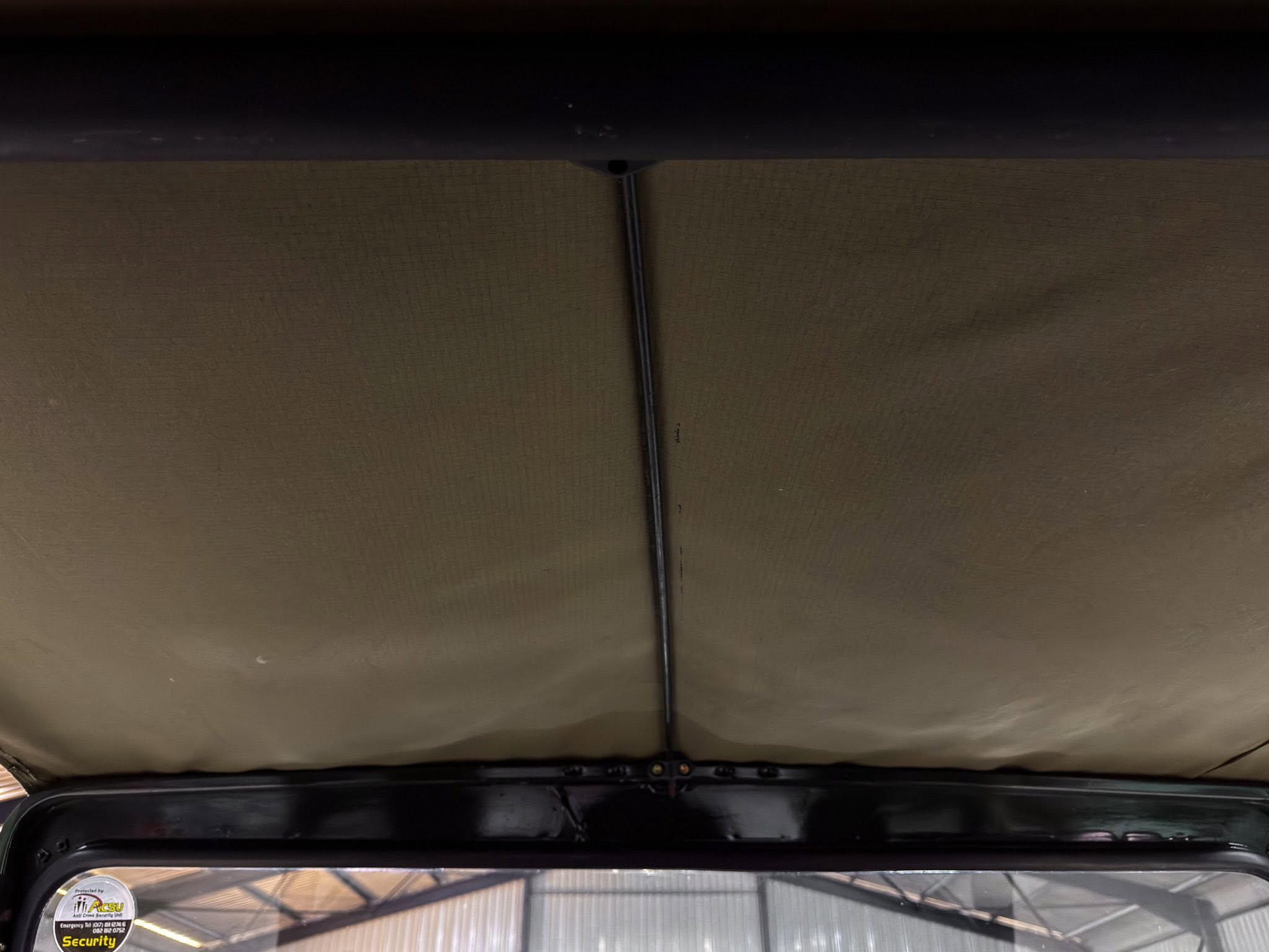 Rear interior of a car showing a black cable running along the ceiling toward the back, with the hatch area visible below.